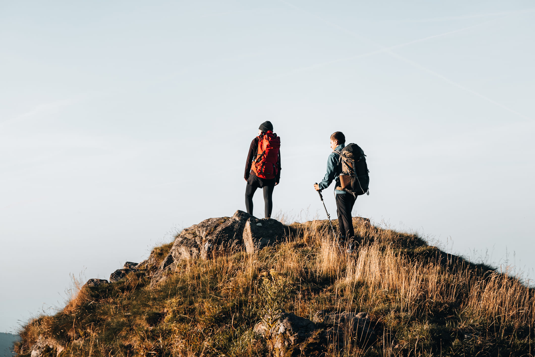 Personen die op grasachtige bergtop staan